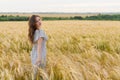 Young pretty woman in dress poses on wheat field Royalty Free Stock Photo
