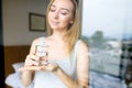 Young pretty woman drinking glass of water at hotel in morning. Royalty Free Stock Photo