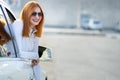 Young pretty woman driver in sunglasses looking out the car front window on a sunny summer day Royalty Free Stock Photo