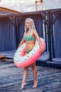 Young Pretty Woman In Green Bikini With Inflatable Circle Standing On The Floor. Royalty Free Stock Photo