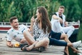 Young pretty woman and handsome man flirting while relax on picnic near river