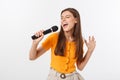 Young pretty woman happy and motivated, singing a song with a microphone, presenting an event or having a party, enjoy Royalty Free Stock Photo