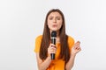 Young pretty woman happy and motivated, singing a song with a microphone, presenting an event or having a party, enjoy Royalty Free Stock Photo