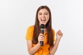 Young pretty woman happy and motivated, singing a song with a microphone, presenting an event or having a party, enjoy Royalty Free Stock Photo