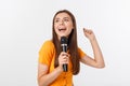 Young pretty woman happy and motivated, singing a song with a microphone, presenting an event or having a party, enjoy Royalty Free Stock Photo