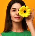 Young pretty woman hold yellow gerbera flower in green dress Royalty Free Stock Photo