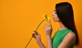 Young pretty woman hold yellow gerbera flower in green dress Royalty Free Stock Photo