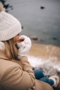 Young pretty woman holding cup of tea enjoying winter frozen nature by the sea Royalty Free Stock Photo