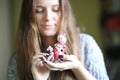 Young pretty woman is holding the little cute elf toy on the rocking horse, christmas toy in the hands Royalty Free Stock Photo