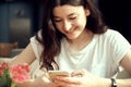 Young pretty woman holding and using smartphone, browsing internet, chatting online, Royalty Free Stock Photo