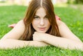 Young pretty woman lying on green grass in park Royalty Free Stock Photo