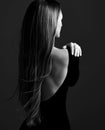 Young pretty woman model standing backwards in dress with open back and showing her gorgeous silky long straight hair Royalty Free Stock Photo