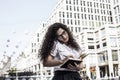 Young pretty woman in office style clothing make notes in her notebook and talking on the phone with somebody Royalty Free Stock Photo