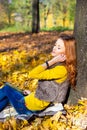 Young pretty woman in the park listening music in autumn