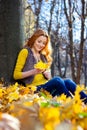 Young pretty woman in the park listening music in autumn