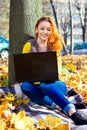 Young pretty woman in the park listening music in autumn