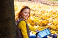 Young pretty woman in the park listening music in autumn