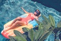 Young pretty woman with perfect tanned body lying on air mattress in the pool in summer and having fun. Relaxing Royalty Free Stock Photo