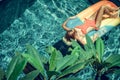 Young pretty woman with perfect tanned body lying on air mattress in the pool in summer and having fun. Relaxing Royalty Free Stock Photo