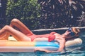 Young pretty woman with perfect tanned body lying on air mattress in the pool in summer and having fun. Relaxing Royalty Free Stock Photo