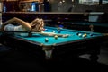 young pretty woman playing alone snooker holding cue at pool table Royalty Free Stock Photo