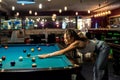 young pretty woman playing alone snooker holding cue at pool table Royalty Free Stock Photo