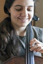 Young pretty woman playing violoncello