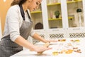 Young pretty woman prepares the dough and bakes gingerbread and cookies in the kitchen. Merry Christmas and Happy New Royalty Free Stock Photo