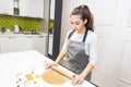 Young pretty woman prepares the dough and bakes gingerbread and cookies in the kitchen. Merry Christmas and Happy New Royalty Free Stock Photo