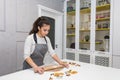 Young pretty woman prepares the dough and bakes gingerbread and cookies in the kitchen. Merry Christmas and Happy New Royalty Free Stock Photo