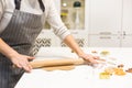 Young pretty woman prepares the dough and bakes gingerbread and cookies in the kitchen. Merry Christmas and Happy New Royalty Free Stock Photo