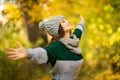 Young woman with raised hands enjoy autumn sunny weather in park Royalty Free Stock Photo