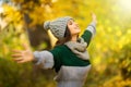 Young woman with raised hands enjoy autumn sunny weather in park Royalty Free Stock Photo