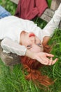 Young pretty woman with red hair lying on garden bench relaxing Royalty Free Stock Photo