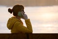 Young pretty woman sitting on a bench talking on her mobile phone outdoors in the evening Royalty Free Stock Photo