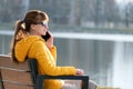 Young pretty woman sitting on a bench talking on her mobile phone outdoors in the evening Royalty Free Stock Photo