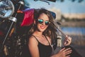 Young pretty  woman sitting on ground next to nake racer motorbike Royalty Free Stock Photo