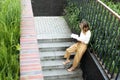 Young pretty woman sitting at opened window drinking tea and reading a book enjoys of rest Royalty Free Stock Photo