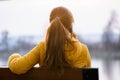 Young pretty woman sitting on a park bench talking on her smartphone outdoors in warm autumn evening Royalty Free Stock Photo