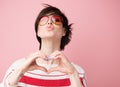 Young pretty woman  smiling and looking at camera with hands on chest, love gesture and kiss. Royalty Free Stock Photo