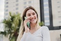 Young pretty young woman smiling and talking by a smartphone device. Happy blonde lady having a phone call at city urban Royalty Free Stock Photo
