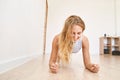 Young pretty woman standing in plank. Yoga exercise at gym. Home sport workout Royalty Free Stock Photo