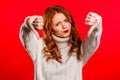 Young pretty woman standing on red studio background expressing discontent