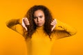 Young pretty woman standing on yellow studio background expressing discontent