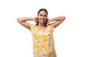 a young pretty woman with straight black hair in a yellow sundress with a daisy pattern smiles shyly Royalty Free Stock Photo