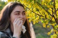 A young pretty woman is suffering from allergies. Red eyes and running snot. The concept of seasonal allergies and colds. Close up Royalty Free Stock Photo