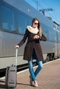 Young pretty woman with a suitcase looking at time Royalty Free Stock Photo