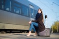 Young pretty woman with a suitcase on the train station Royalty Free Stock Photo