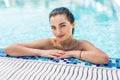 Young pretty woman in sunglasses looking at camera while swimming in pool Royalty Free Stock Photo