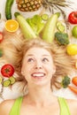 A young pretty woman surrounded by vegetables and fruits Royalty Free Stock Photo